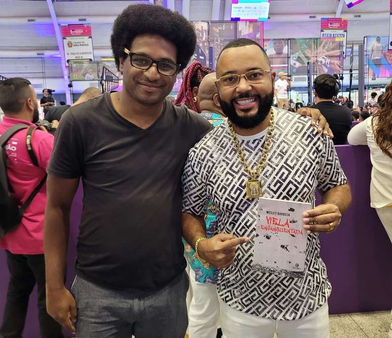 Escritor Wesley Batista vende seus livros para anônimos e famosos, com Dudu Nobre, na Expo Favela