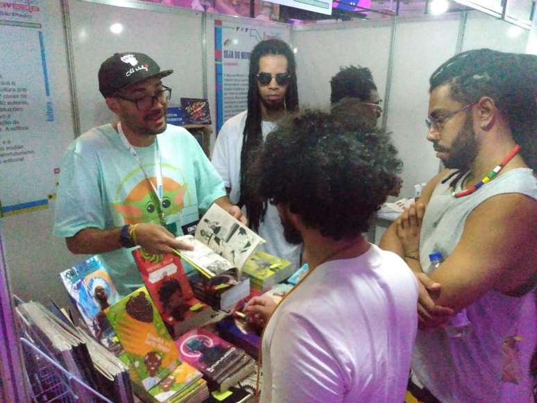 Israel Neto, da editora Kitembo, no estande da Expo Favela. Maioria das vendas é no corpo a corpo.