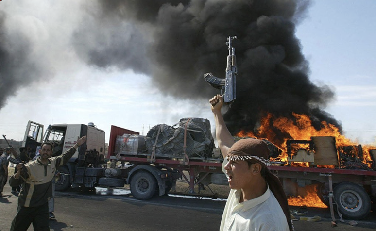 Iraquianos sunitas em frente a um comboio dos EUA em chamas nos arredores de Fallujah em 2004