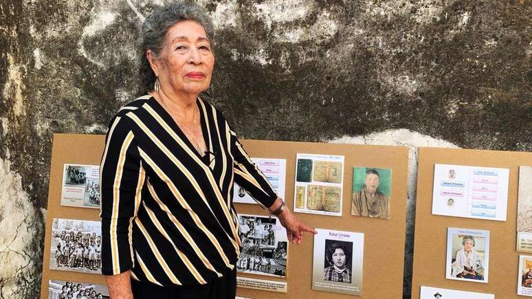 Rosa Urano guarda muitas lembranças de sua estada na ex-fazenda. Na imagem, ele aponta para uma de suas fotos de 17 anos, sob a foto do passaporte do pai