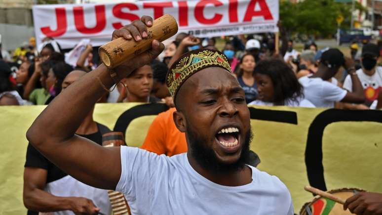 Imagem mostra afro-colombianos em protesto contra o racismo e por justiça no assassinato de cinco adolescentes negros.
