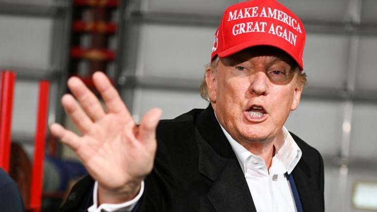 Trump wearing a red hat that reads 'Make America Great Again'