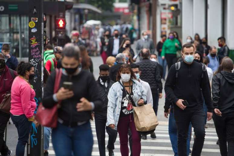 Imagem mostra pedestres na Avenida Paulista, em São Paulo, utilizando máscaras contra a covid-19.