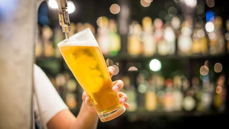 Imagem meramente ilustrativa de uma pessoa enchendo um copo de cerveja