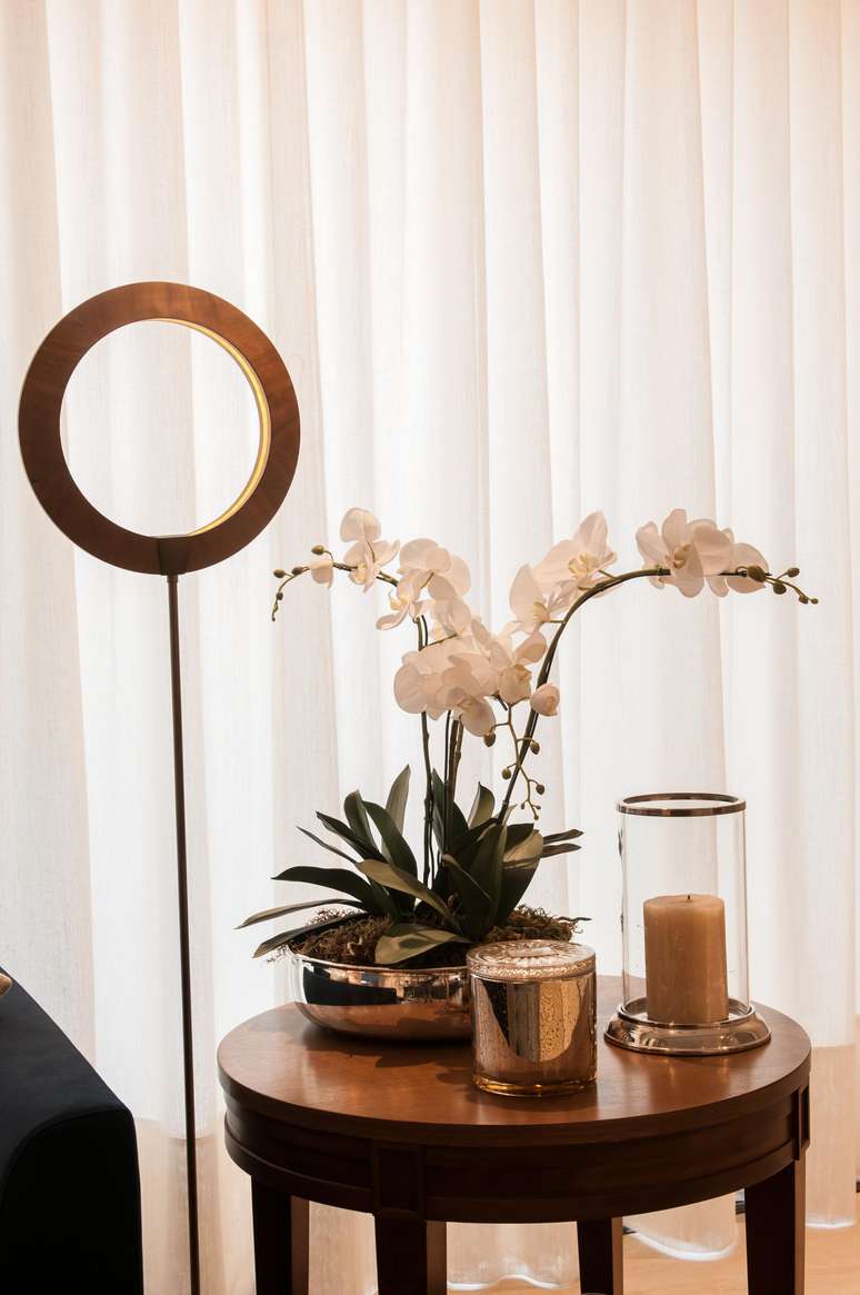 Ao lado do sof&aacute;, a mesinha recebeu flor e velas: &eacute; exatamente este tipo de detalhe que faz toda a diferen&ccedil;a na hora de finalizar o c&ocirc;modo e assegurar o aconchego. Projeto: Paiva e Passarini - Arquitetura.
