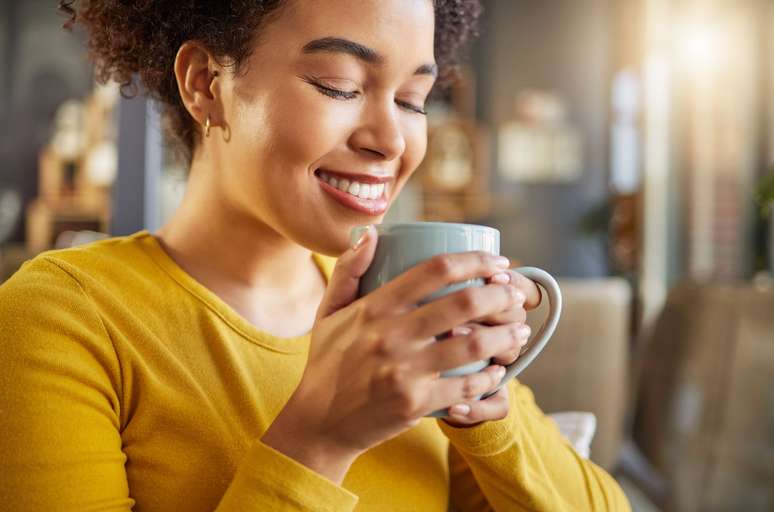 Imagem meramente ilustrativa de uma mulher tomando café