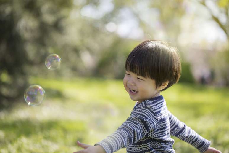 menino oriental sorrindo natureza
