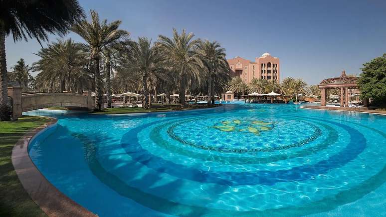 As piscinas são cercadas por coqueiros e vegetação local