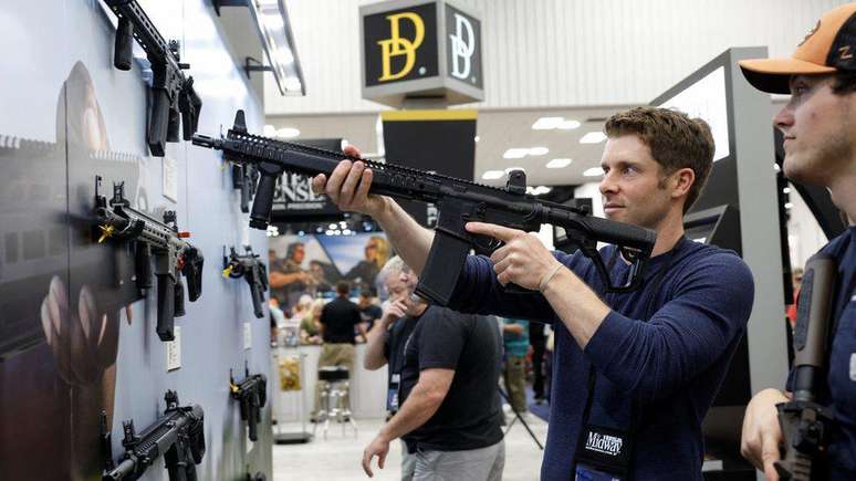 Membro da NRA posa com uma arma estilo AR-15 na convenção anual em Indianápolis, Indiana