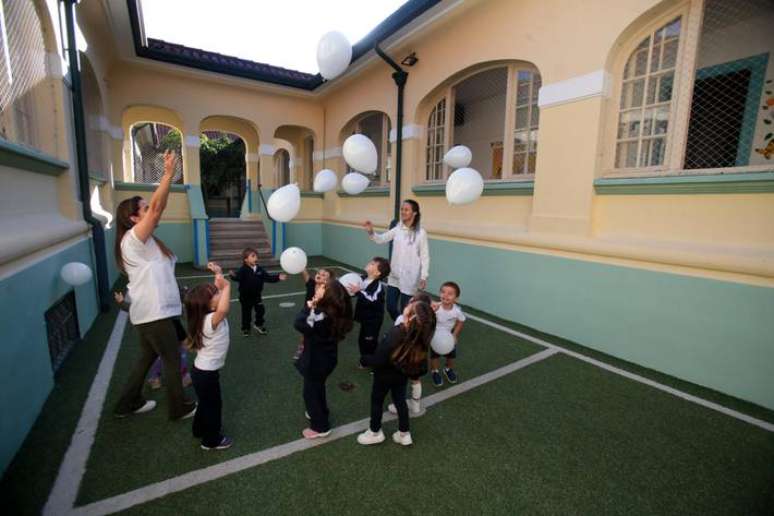 Crianças brincam com balões brancos em atividades nesta quinta-feira no Colégio Pentágono