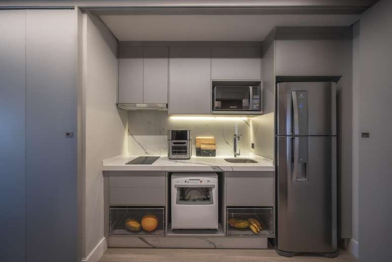 O ideal da marcenaria planejada &eacute; aproveitar todos os cantos do ambiente de forma inteligente, funcional e discreta. Nesse projeto, o destaque s&atilde;o as gavetas de fruteiras, a economia de espa&ccedil;o e os eletrodom&eacute;sticos embutidos &ndash; incluindo cooktop por indu&ccedil;&atilde;o e lava lou&ccedil;as. Projeto de PB Arquitetura.