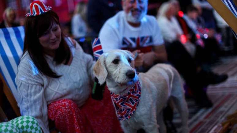 Já este cãozinho assistiu à coroação com uma bandana com a bandeira do Reino Unido –