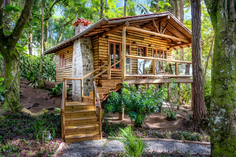 The photo shows a wooden chalet with a stone fireplace.
