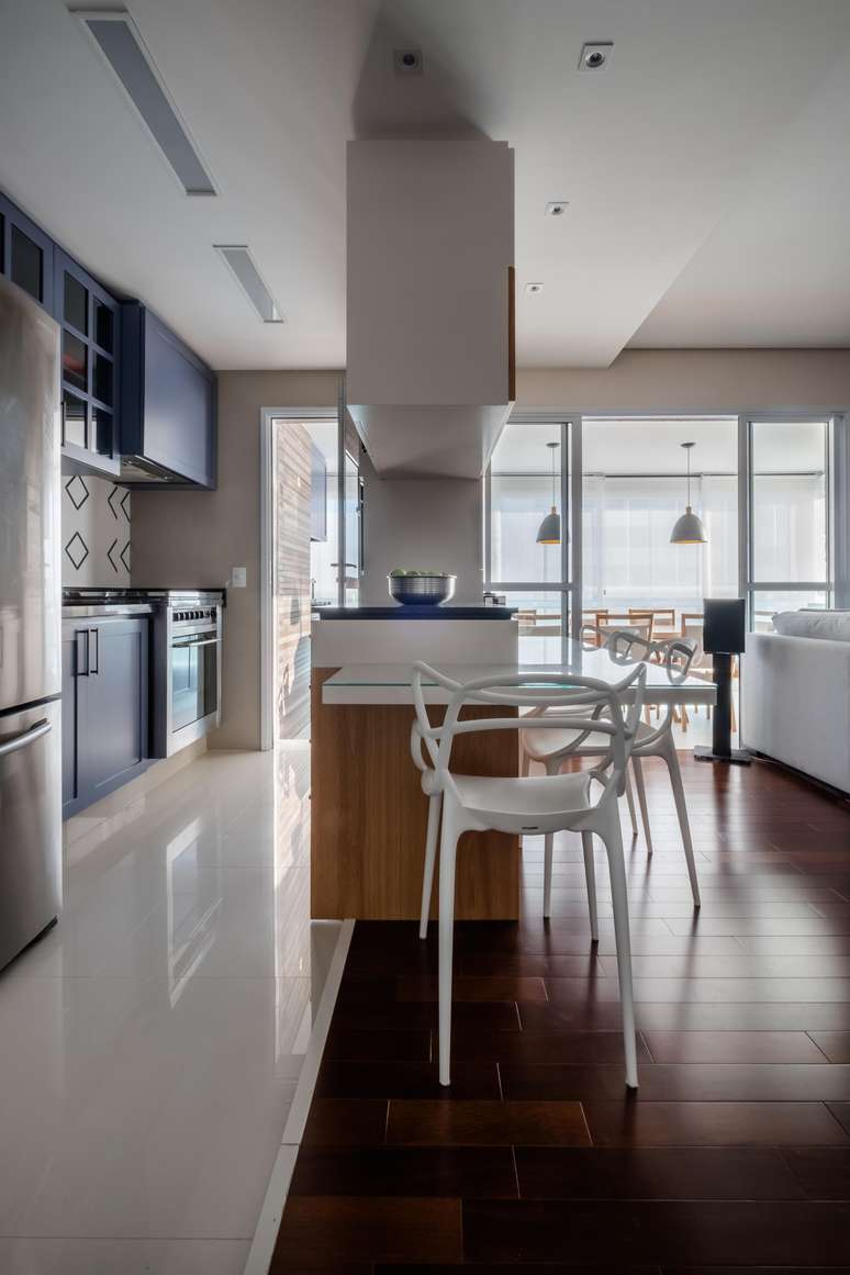 Located at the top of the cabinet, the porcelain sideboard has white joinery, as opposed to the blue found mostly in the kitchen joinery.  With this balance, Claudia and Monike, from Studio Tan-gram, have created an elaborate and relaxed aesthetic game that dialogues with the composition of the tiles chosen for the pediment.