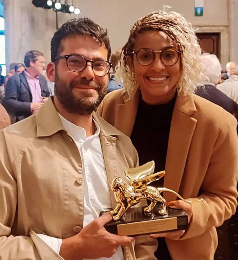 Paulo Tavares e Gabriela de Matos com o Leão de Ouro da Bienal de Arquitetura de Veneza 2023.