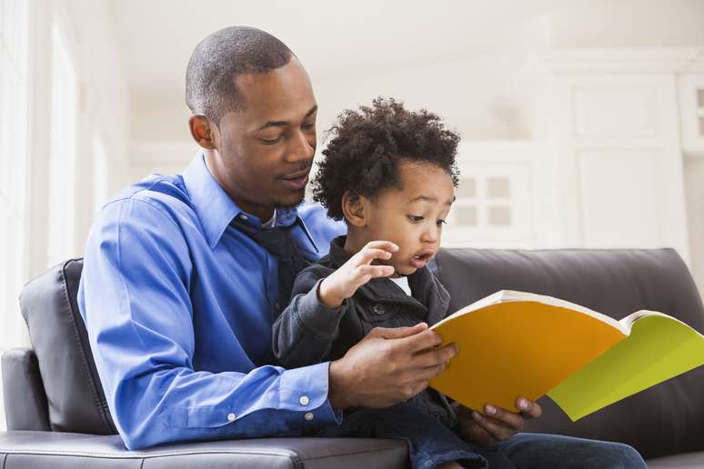 father and son reading on the sofa