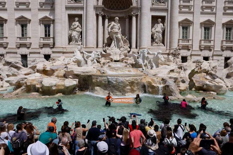 Ativistas climáticos despejam carvão vegetal na água da Fontana di Trevi, durante uma manifestação contra os combustíveis fósseis, em Roma, Itália, 21 de maio de 2023 nesta imagem obtida nas redes sociais