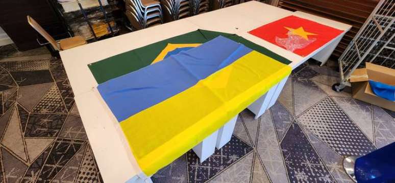Bandeira do Brasil e da Ucrânia sobrepostas em área reservada à imprensa.