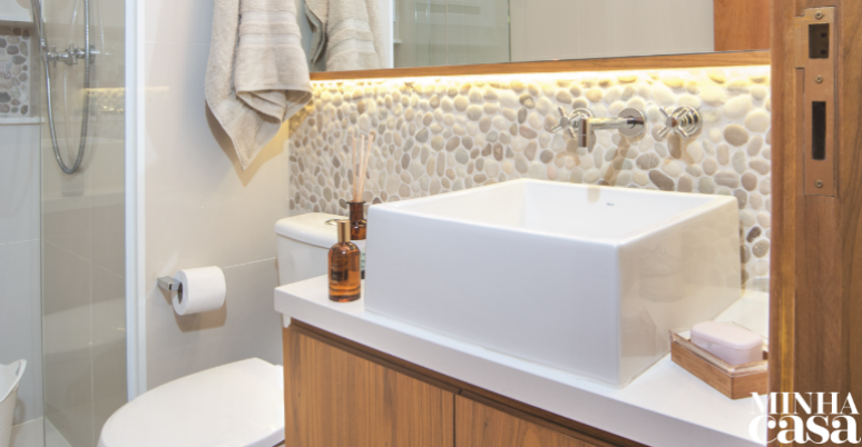 O ponto de atra&ccedil;&atilde;o deste banheiro assinado por Ana Carolina e Mariana Lima Orsolini &eacute; a parede forrada com seixos rolados.