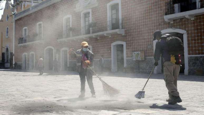 Trabalhadores de limpeza tiveram que varrer cinzas vulcânicas das ruas em Puebla