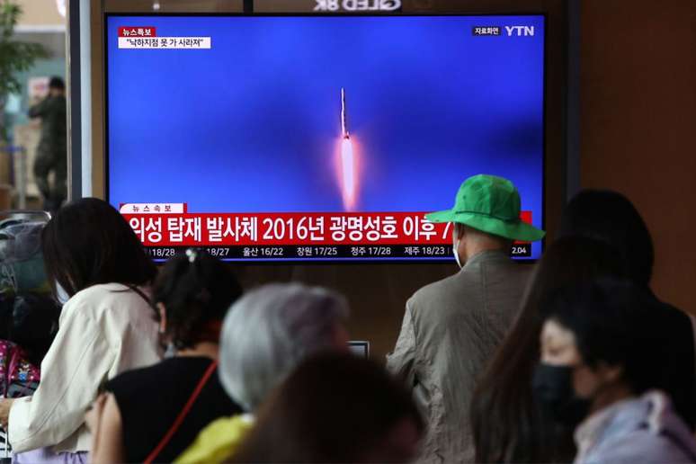 Pessoas em Seul, Coreia do Sul, assistem pela TV o lançamento de satélite norte