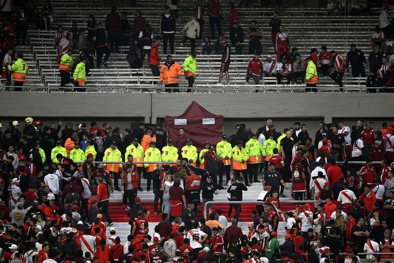 Corpo do torcedor Pablo Serrano é encoberto com um toldo (ao fundo)  para evitar a curiosidade e fotos. Ele teve morte instantânea e o jogo do River com Defensa foi suspenso – Diego Haliasz/Getty Images