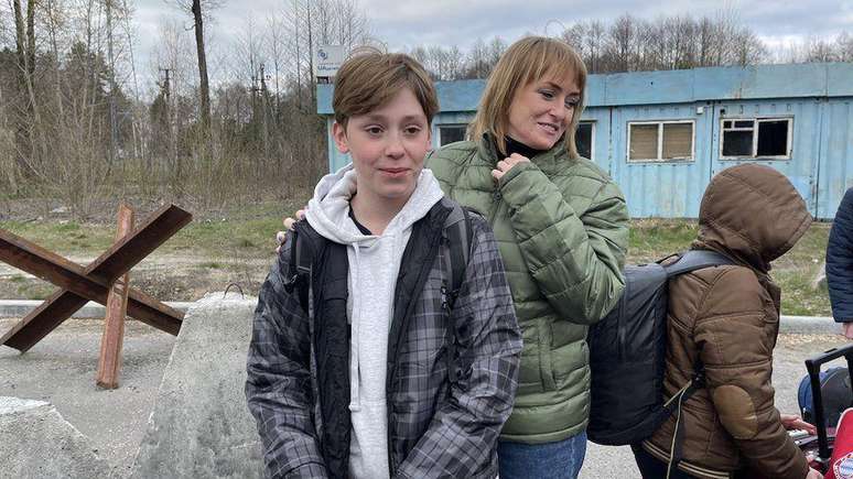 Danylo (centro) ao cruzar a fronteira da Bielorrússia para a Ucrânia depois de meses longe de casa