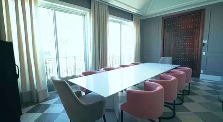 In the dining room, the pink armchairs stand out In the dining room, the pink armchairs stand out