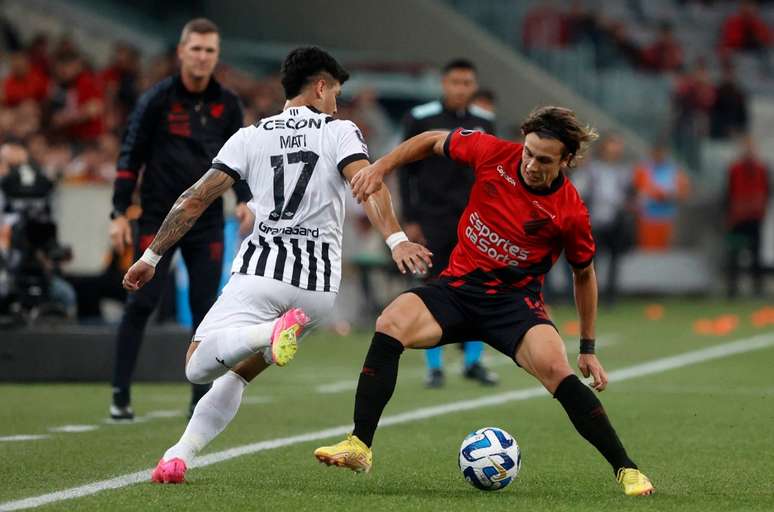 O atleticano Canobbio (de vermelho) disputa a bola com o lateral-esquerdo Espinoza, do Libertad – AFP