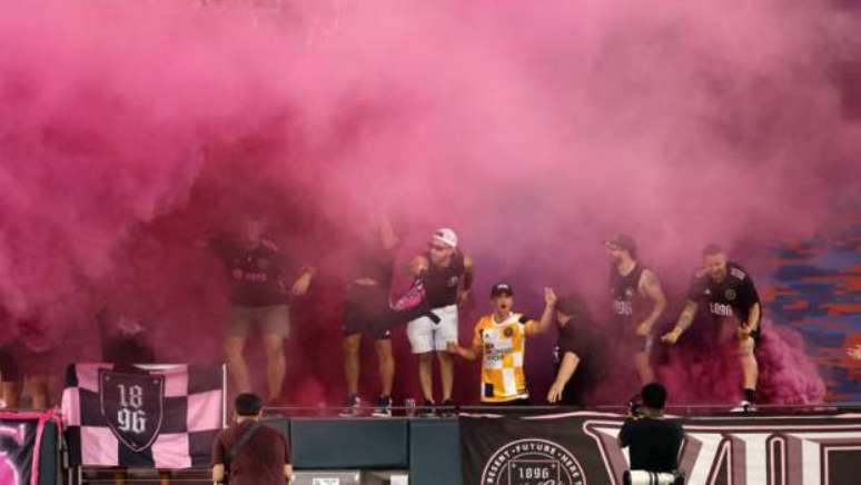 Torcedores no meio de fuma&ccedil;a rosa