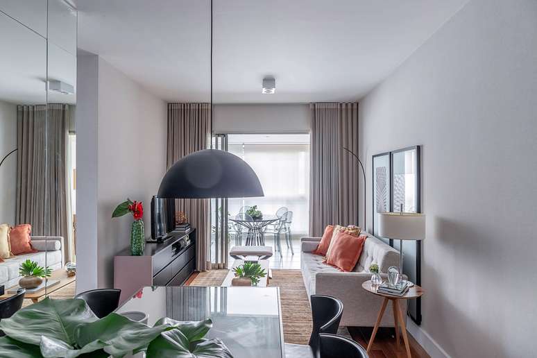Combined with light tones, in this apartment, the architect Carina Dal Fabbro has invested in integrating the living room and dining room.  She explains that applying the same shade of paint to cover the walls allows light to reflect, giving the impression of a larger, more airy space.
