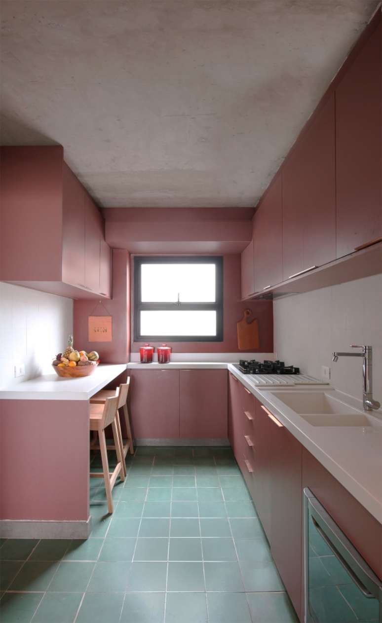Ladrilho hidr&aacute;ulico cria unidade visual neste apartamento de 140 m&sup2;. Projeto do Studio MEMM. Na foto, cozinha com piso verde de ladrilho hidr&aacute;ulico e marcenaria rosa.