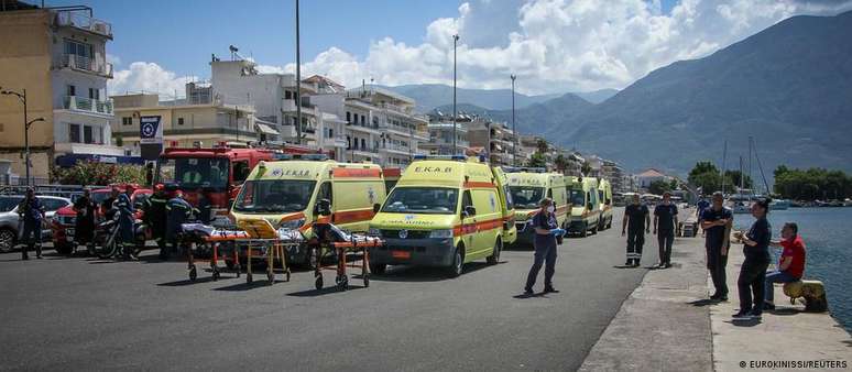 Equipes de emergência em Kalamata aguardam a chegada de sobreviventes resgatados do mar 