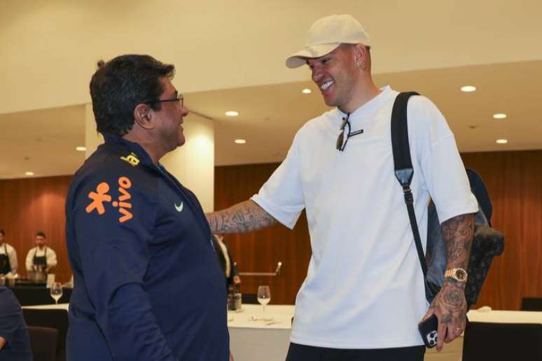 Ederson (esq.) cumprimenta o presidente Ednaldo Rodrigues (dir.) na apresenta&ccedil;&atilde;o &agrave; sele&ccedil;&atilde;o brasileira em Barcelona.