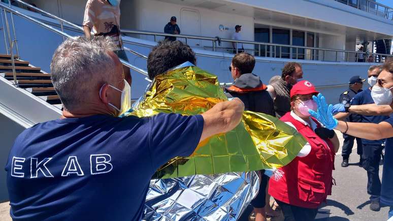 Equipes socorrem sobreviventes em barco de resgate que desembarcou em Calamata