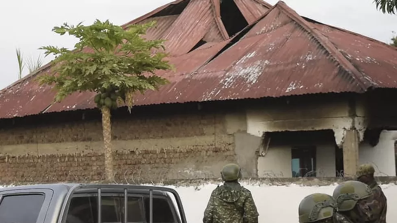 Agentes das forças de segurança de Uganda em frente à escola secundária Lhubiriha, em Mpondwe