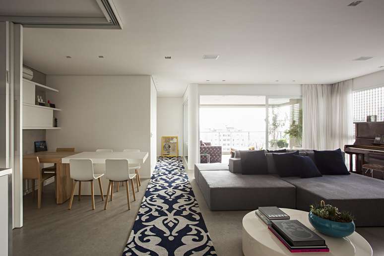 Acting as a room delimiter, the rug rests on the gray limestone floor and divides the living room from the dining room.  Korman Architects project.