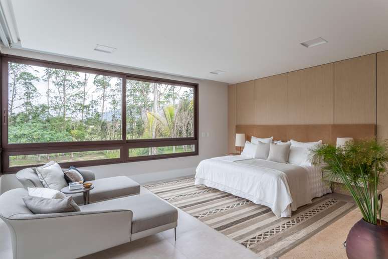 Tone on tone was also present in this bedroom, with earth tones chosen by the architect Patricia Penna, starting with a more pastel color on the carpet, and continuing with more vibrant tones, such as the wood of the headboard and the brown of the structures the large windows.