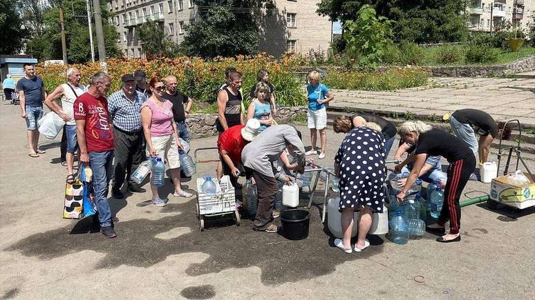 Moradores fazem fila para ter acesso a água em Marhanets, cidade ucraniana que frequentemente é alvo de ataques russos