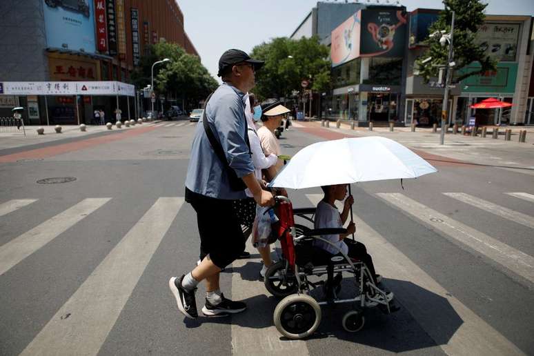 Pedestres atravessam a rua em um dia quente com alerta laranja de onda de calor em Pequim, na China (16/06/2023)