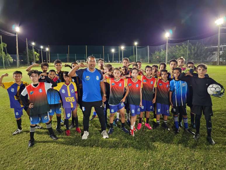 Garotada do projeto do CRA faz o muque de Tiquinho junto de Nildo Lima, o primeiro t&eacute;cnico &ndash;