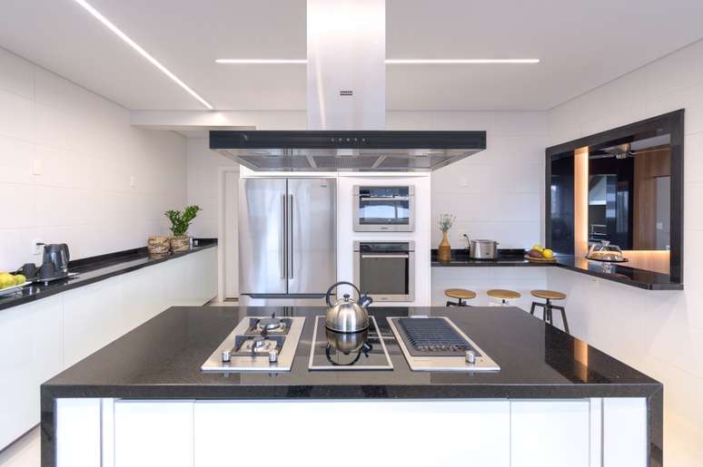 Kitchen island with stainless steel hob and extractor hood.