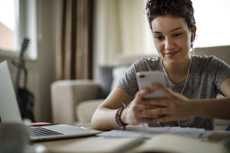 Jovem estudando pelo celular