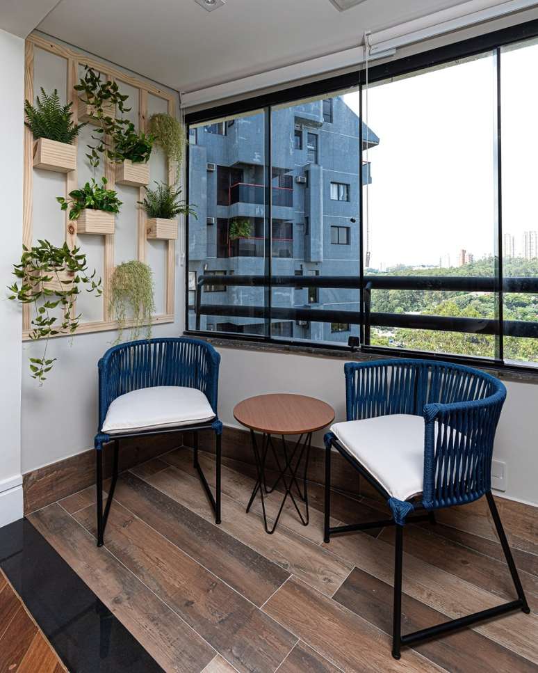 The contemporary and industrial style distinguishes the decoration of this 110 m² apartment.  Project studio wall architecture.  In the photo, balcony with vertical garden and blue rope chairs.