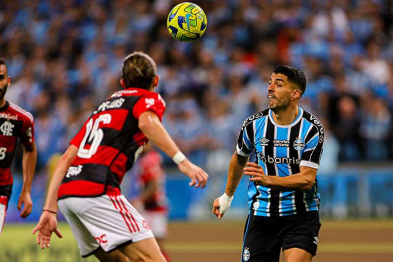 Suárez lutou, mas passou em branco na Arena do Grêmio; já o Fla de Filipe Luís levou a melhor. Na foto, o atacante gremista e o lateral rubro-negro disputam a bola