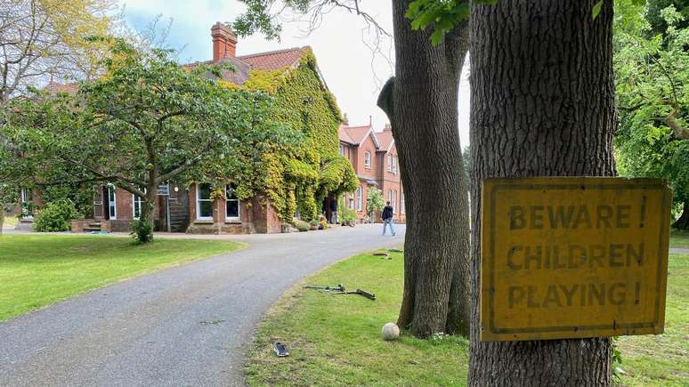 Placa 'Atenção! Crianças brincando!' dá boas-vindas a visitantes de Summerhill