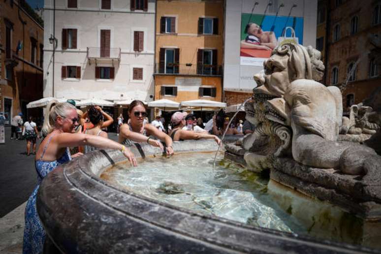 Turistas se refrescam do calor em fonte de Roma, na It&aacute;lia