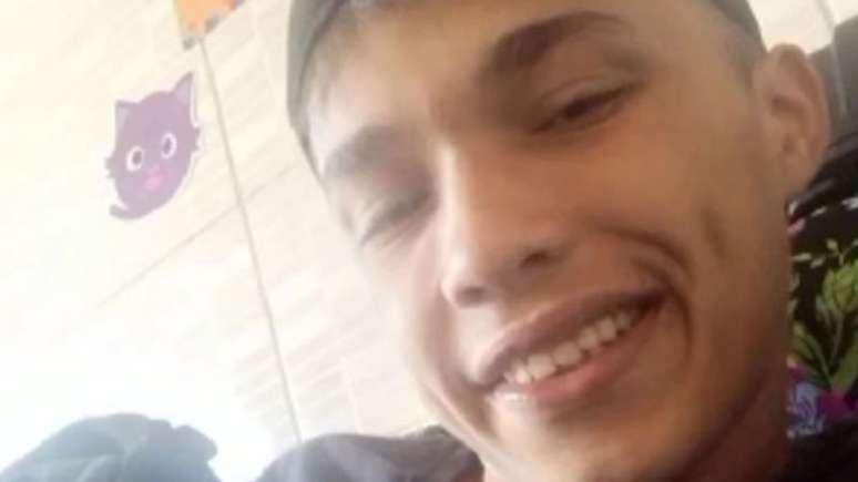 Imagem mostra o jovem que foi baleado e morto pelo seguran&ccedil;a clandestino. Ele est&aacute; com uma camisa preta e sorri.