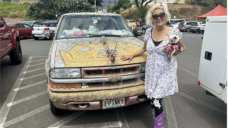 Pinky ao lado de sua caminhonete decorada com gliter usada para salvar pessoas no incêndio