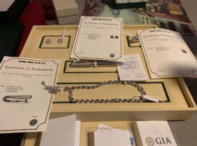 Imagem mostra caneta, joias e item religioso em ouro branco